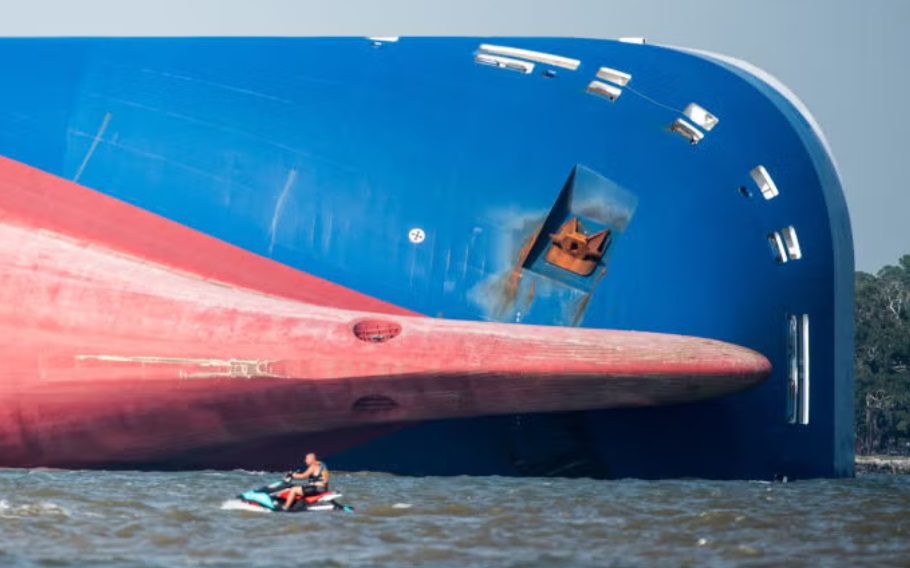 The capsized RORO ship MV Golden Ray. Jet ski next to big ship. Submechanophobia.
