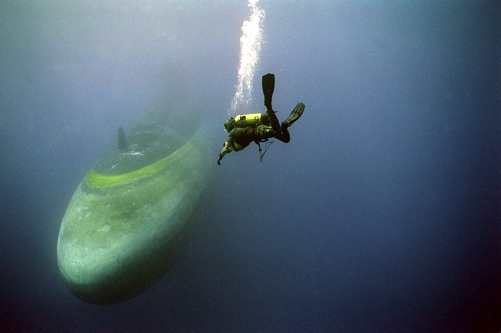 Diver next to submarine. Submechanophobia.